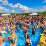 Hundreds of people enjoying a daytime pool party at Imagine Music Festival 2023