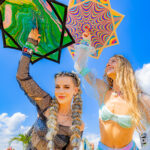 Two white women spinning flowstars under a blue sky at Imagine Music Festival 2023
