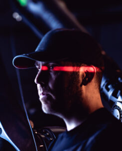 photo of man in a black hat with a red light across his face